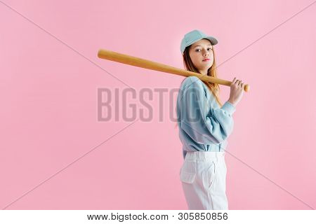 Pretty Teenage Girl In Cap Holding Wooden Baseball Bat Isolated On Pink