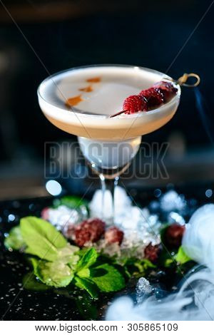 A Lifestyle Photo Of A Clover Club Alcoholic Drink In A Cocktail Glass, Standing On A Steel Barstand