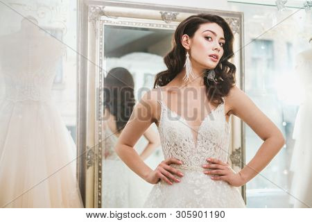 Beautifu bride choosing wedding dress in a wedding salon