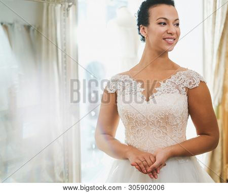 Beautifu bride choosing wedding dress in a wedding salon