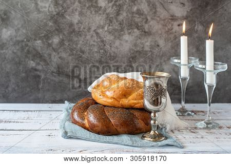 Shabbat Shalom - Challah Bread, Shabbat Wine And Candles On Grey Background. With Copy Space.