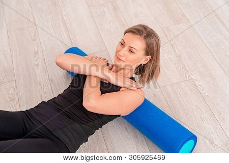 Woman Doing Exercise With A Roller. The Girl Lies Back On The Gymnastic Roller Back, Arms Crossed Ov