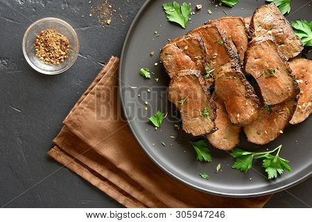 Grilled Sliced Beef Liver On Plate Over Black Stone Background. Cooked Liver(offal) From Beef Meat. 