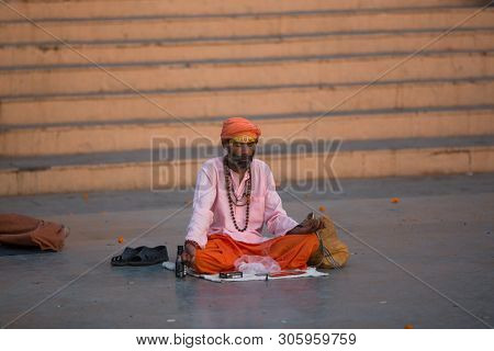VARANASI, INDIA - MAR 21, 2018: Sadhu or Baba (holy man) on the ghats of Ganges river. Normally a sadhu is a monk, renounced, renounced material enjoyment. In India from 4 to 5 million sadhu.