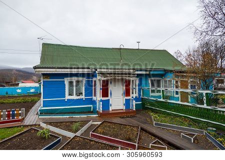 Esso, Kamchatka Peninsula, Russia- 02 October 2014: Wooden Small Blue House With Green Roof. Vegetab