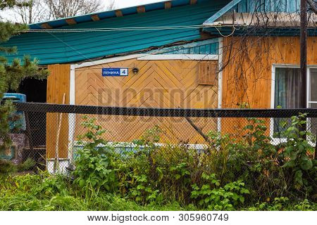 Esso, Kamchatka Peninsula, Russia- 02 October 2014: Wooden, Small House With Blue Roof. Fence And Hi