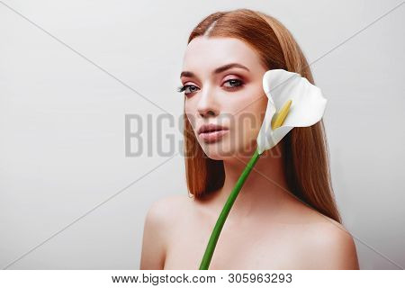 Portrait Of Happy Young Redhead Lady Looking Out Of White Flowers Studio Shot