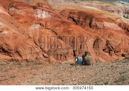 Relaxing man and woman in Valley of Mars landscapes in the Altai Mountains, Kyzyl Chin, Siberia, Russia