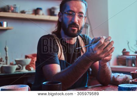 Diligent Entusiastic Master In Glasses At His  Pottery Studio Is Workig For A New Dish.