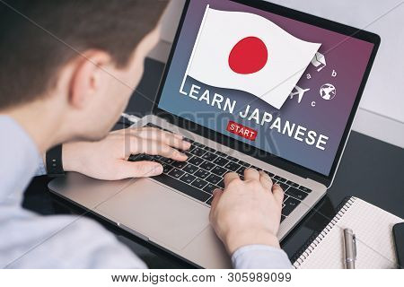 Man Working On Laptop With Learn Japanese On A Screen. Education Learning Japanese Language School C