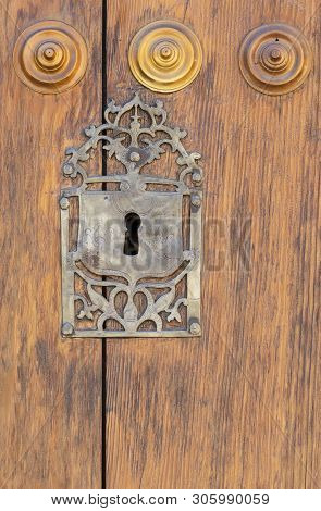 Keyhole In An Old Paneled Wooden Door; Rusty And Weathered