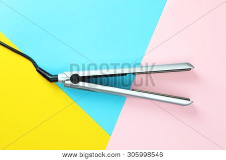 Modern Hair Iron For Straightening On Color Background, Top View