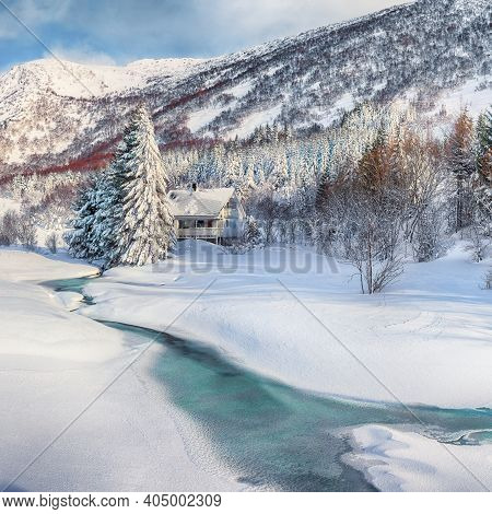 Fabulous Winter Scenery With Frozen River With Wooden Houses And Snow Covered Pine Trees Near Valber