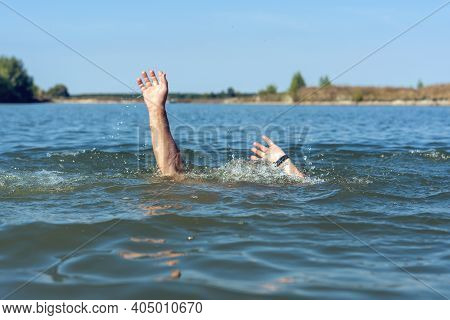 Hands Of A Drowning Man Above Water In Need Of Help.
