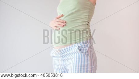 Pregnant Woman Holding Hands On Her Belly. Belly Of A Pregnant Woman On 16 Week, 4 Month. A Woman Is