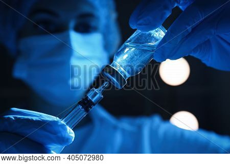 Woman Filling Syringe With Vaccine From Vial On Black Background, Closeup