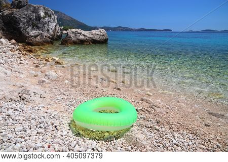 Mlini Beach In Croatia. Dalmatia Region Adriatic Sea Coast. Inflatable Wheel Float Toy.