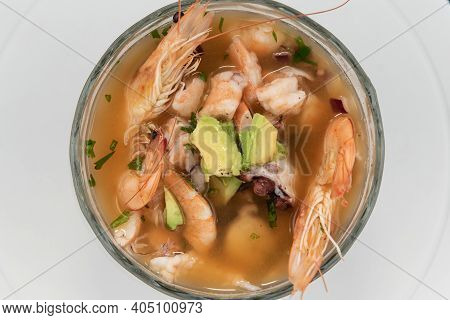 Overhead View Of Bowl Of Warm Shrimp Broth With Head And Tail Included In Soup.