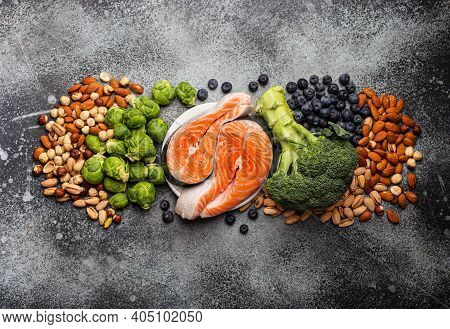 Assorted Food For Brain Health And Good Memory: Fresh Salmon, Vegetables, Nuts, Berries On Stone Bac