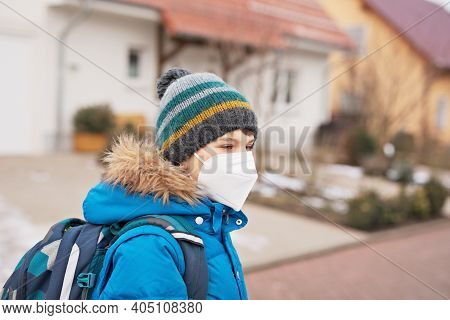 Kid Boy Wearing Ffp Medical Mask On The Way To School. Child Backpack Satchel. Schoolkid On Cold Aut