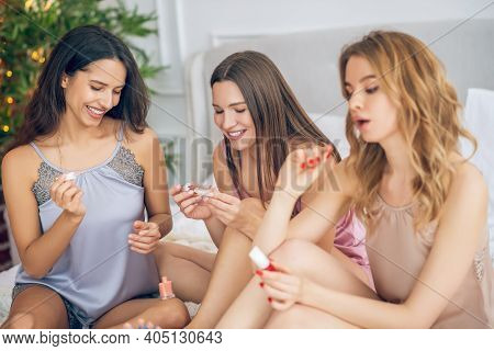 Cute Girls In Lingerie Doing Nail Polishing And Looking Involved