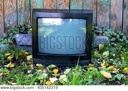 Old Analog Television Set On The Weathered Wooden Planks Background