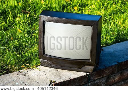 Old Analog Television Set On The Grass Background Outdoor