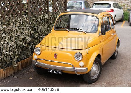 Barga. Italy. Summer 2019. Old Small Car In The City. Only Such A Car Can Move Around The Streets Of