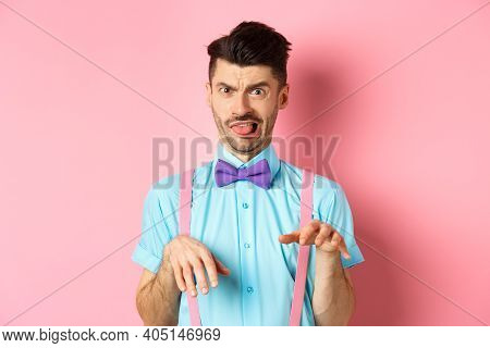 Funny Guy Looking At Something Disgusting With Aversion And Cringe, Show Tongue And Shaking Hands In