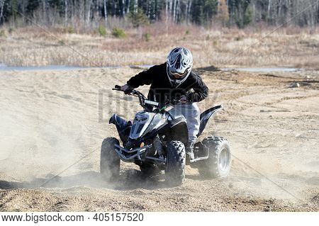 A Young Boy Spins His Quad Wheels Making Dust