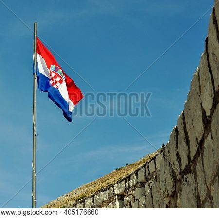 Croatian Flag With Stone Wall And Big Sky.