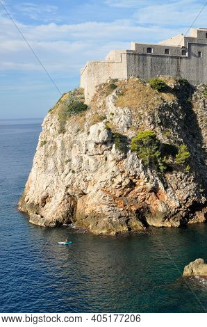 Kayak Below Cliff At Fort Lovrijenac In Dubrovnik
