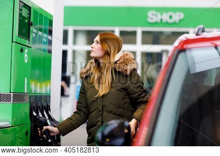 Young Caucasian Woman At Self-service Gas Station, Hold Fuel Nozzle And Refuel The Car With Petrol, 
