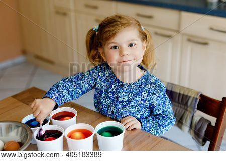 Excited Little Toddler Girl Coloring Eggs For Easter. Cute Happy Child Looking Surprised At Colorful