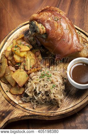 Schweinshaxe Traditional German Pork Knuckle With Sauerkraut And Potatoes Bavarian Meal On Rustic Wo