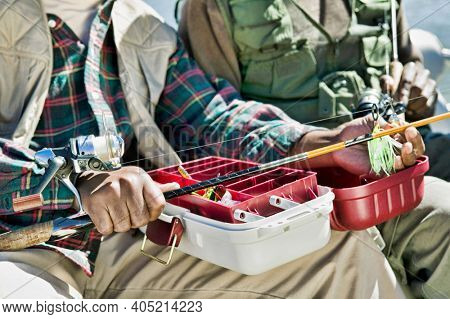 Man Using Tackle Box and Preparing Fishing Pole