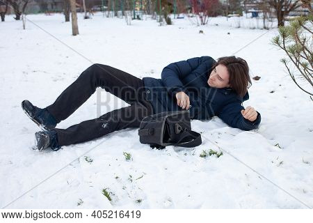 A Man Falls In The Snow. The Man Slipped And Was Injured. Falling On Ice. Winter. Fracture, Bruise,