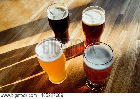 Beer In Glasses On The Table. Sunlight. Four.