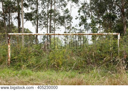 A Soccer Field And A Rusty Goal, Completely Invaded By Vegetation, Near The Village Of Ladrido, In T