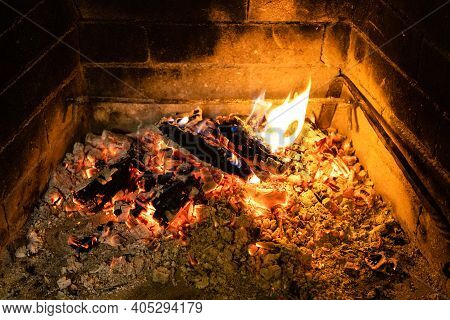 Smoldering Firewood And Hot Ash In Home Fireplace