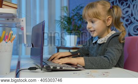 Little Child Girl Doing School Homework Using Laptop At Home. Online E-learning, Children Pupil Dist