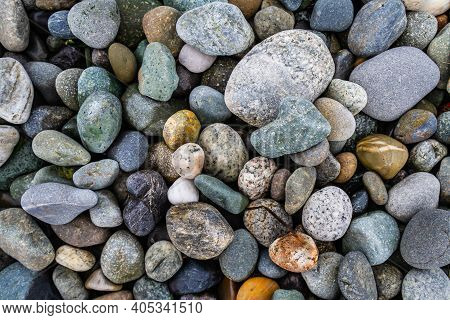 Colorful Smooth Rocks On The Beach Covered In Water.
