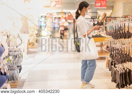 Female Wearing Surgical  And Hands Choosing Bras Cups Size And Looking Light New Wireless And Seamle