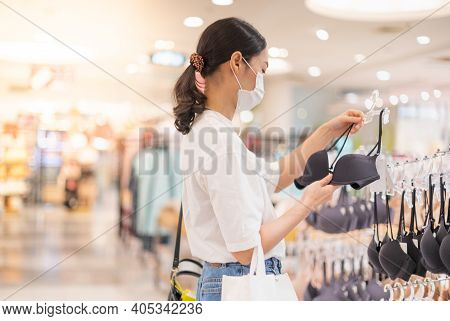 Female Wearing Surgical  And Hands Choosing Bras Cups Size And Looking Light New Wireless And Seamle