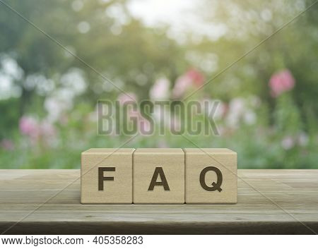 Faq Word On Block Cubes On Wooden Table Over Blur Pink Flower And Tree In Garden, Frequently Asked Q