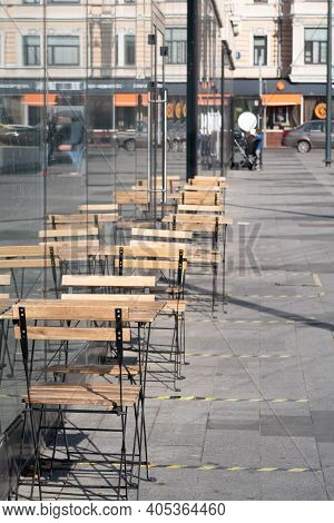 Glass Cafe On Triumfalnaya Square In Moscow. Tables On The Street. Striped Quarantine Markings. Refl