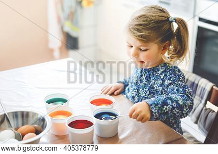 Excited Little Toddler Girl Coloring Eggs For Easter. Cute Happy Child Looking Surprised At Colorful