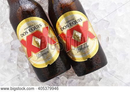 IRVINE, CA - JUNE 14, 2017: Dos Equis Blanca on ice. Two bottles of the wheat beer from Cuauhtemoc-Moctezuma Brewery in Monterrey, Mexico a subsidiary of Heineken International.