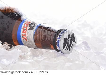 IRVINE, CA - JUNE 14, 2017: Tecate Light bottle on Ice.  A bottle of Tecate Light, a popular pale lager named after the city of Tecate, Baja California, where it was first produced in 1943.
