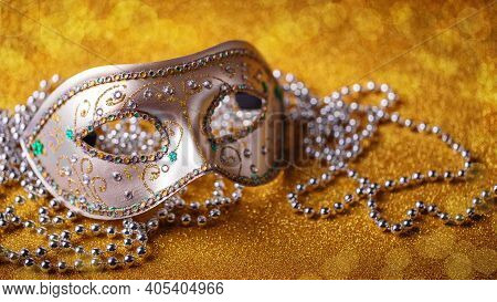 Festive, Colorful Mardi Gras Or Carnivale Mask And Beads On Golden Background. Venetian Masks. Party
